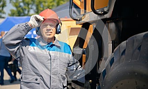 Driver yellow big truck on coal at open pit mining. Concept industry man worker