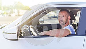 The driver is a young attractive man driving a car.