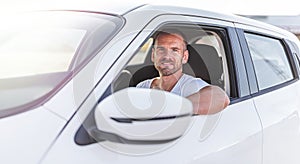 The driver is a young attractive man driving a car.