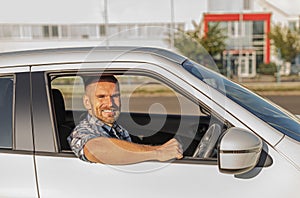 The driver is a young attractive man driving a car.