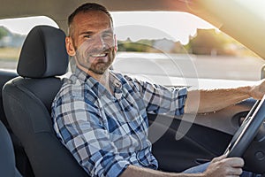 The driver is a young attractive man driving a car.