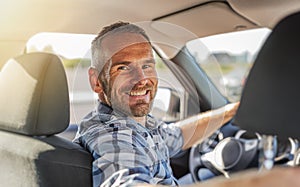 The driver is a young attractive man driving a car.
