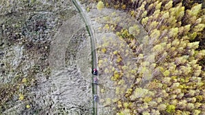 Drivers of ATVs, buggies in the autumn forest, shooting from a quadcopter