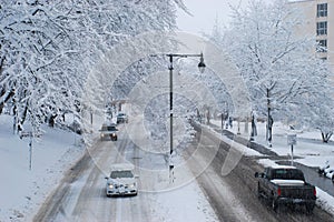 Drivers navigate a snow covered road while snowing