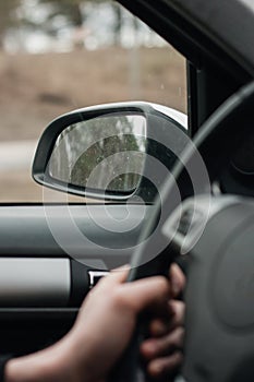 Drivers's hands on a left stearing,steering wheel of a car