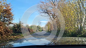 Drivers view out of a sports car driving along a beautiful small country road