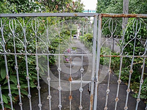 Driveway as seen through a closed iron gate