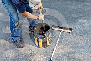 Driveway maintenance, stirring sealant before pouring