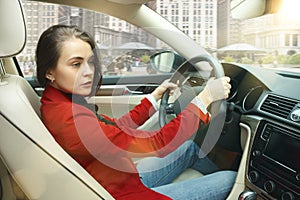 Driving around city. Young attractive woman driving a car