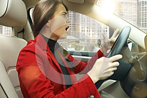 Driving around city. Young attractive woman driving a car