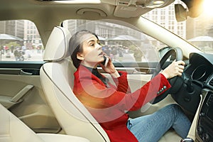 Driving around city. Young attractive woman driving a car