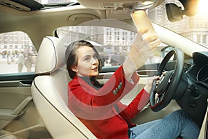 Driving around city. Young attractive woman driving a car