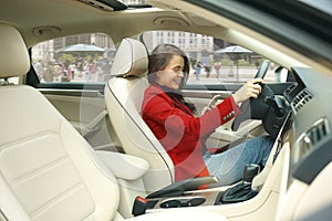 Driving around city. Young attractive woman driving a car