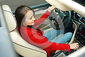 Driving around city. Young attractive woman driving a car