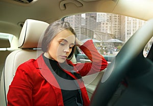 Driving around city. Young attractive woman driving a car