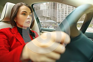 Driving around city. Young attractive woman driving a car