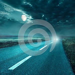 Driving on asphalt road at night towards the headlights