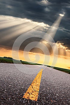 Driving on asphalt road towards the sunbeams