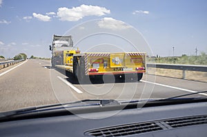 Driving behind empty oversize load truck