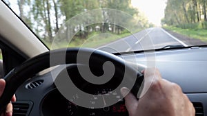 Driving car. Dashboard and speedometer in kilometres per hour. Hands of the driver on the steering wheel