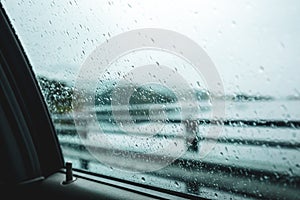 Driving a car in a dodgy weather. Dodge drops on the car window