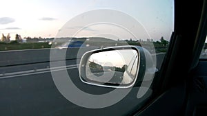 Driving car on the motorway in the morning - back mirror