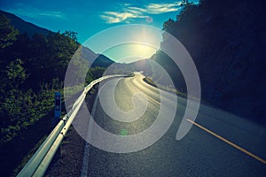 Driving a car on a mountain road at sunset