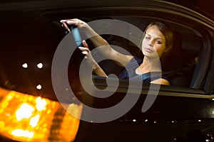 Driving a car at night - pretty, young woman driving her car