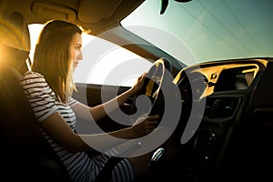 Driving a car at night - pretty, young woman driving her modern car