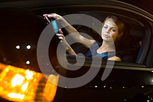 Pretty, young woman driving her modern car at night