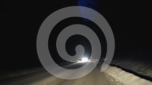 Driving car at night road in winter, snow, slippery blizzard weather mountains forest