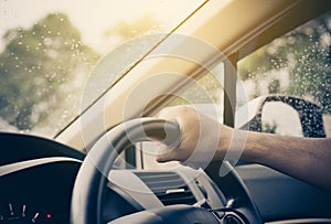 Driving a car after raining,Hand of man driver on steering wheel