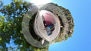 Driving car on a road between trees as 360 degree tiny planet effect