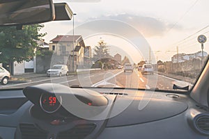 Driving car in urban street with traffic, view from inside, windscreen vehicle interior, backlight, toned vintage