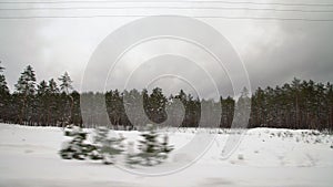Driving with caution on a slippery road covered with snow in the forest. Car driving on empty path in winter