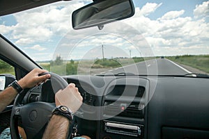 Driving concept â€“ driver hands on wheel and car interior