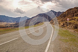 Driving on an empty asphalt road with sign towards the mountain