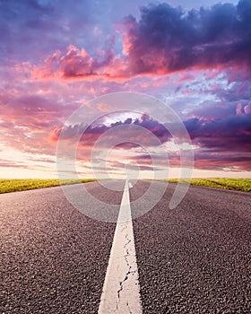 Driving on an empty asphalt road at sunset