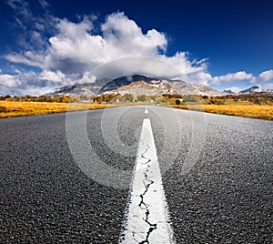 Driving on an empty asphalt road to the mountains