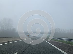 Driving on a empty highway in thick fog.