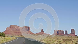 Driving On Famous Road In Monument Valley Usa Background Of High Red Rock Buttes