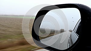 driving on a foggy winter day, mirror view