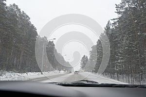driving on a forest road suburb cars in the oncoming lane winter snow trees