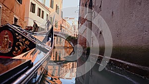 Driving with the Gondola through a small Venezian canal.