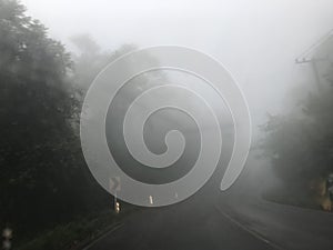 Driving on highway with a lot of fog and yellow keep right road sign