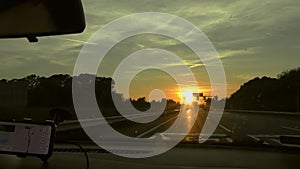 Driving on the highway towards the setting sun. Bumps on the road. Passenger\'s perspective. Highway. Road Intercountry