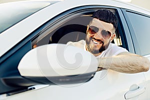 Driving his car, young man smiling while driving a car, Man in the driver`s seat of a car