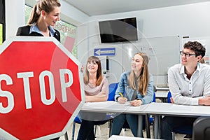 Driving instructor holding theoretical part of driving lessons