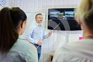 driving instructor pointing at board in classroom