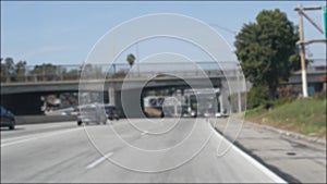 Driving on intercity freeway in Los Angeles, California USA. Defocused view from car thru glass windshield on busy